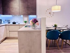 伦敦NEW Cosy 3BR Apartment With Private Garden In Olympic Park的厨房配有桌子和花瓶