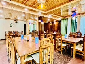 马拉里The Kalinga Resort Manali - Heaven In Mountains的用餐室配有木桌和椅子