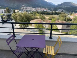 科尔特Magnifique Studio dans Résidence neuve的阳台配有一张紫色桌子和两把椅子