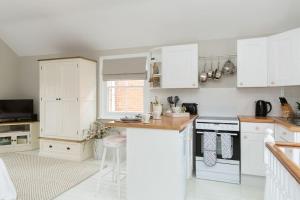 科尔切斯特Stylish and homely 1 bed Edwardian Coach House的厨房配有白色橱柜和台面