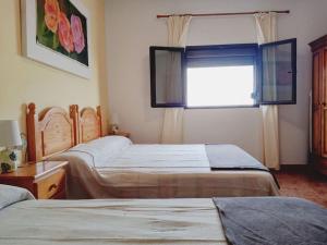 塞博河畔卡莱塔Casa Olga的一间卧室设有两张床,窗户设有