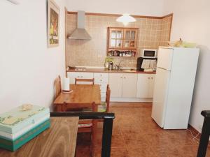 塞博河畔卡莱塔Casa Olga的厨房配有桌子和白色冰箱。