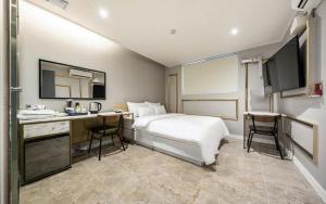 首尔Mnlucky Hotel的配有一张床和一张书桌的酒店客房