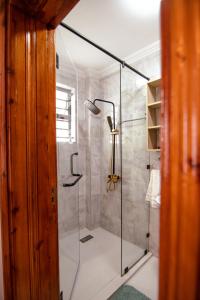 RuiruCadenrockvilla - Furnished 3 bedroom villa with pool的浴室里设有玻璃门淋浴