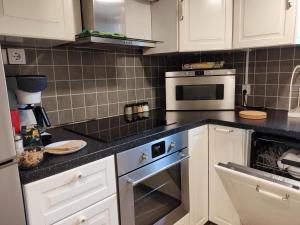 默恩达尔90 m2 charmig källarlägenhet nära natur och stad的厨房配有白色橱柜和炉灶烤箱。
