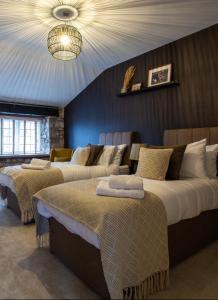 切普斯托The Potting Shed的一间卧室配有两张床和吊灯。