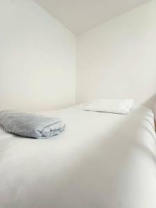 普特拉贾亚Sann's Lodge的白色的床、白色床单和枕头