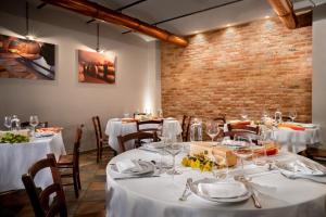 蒙福特达尔巴Agriturismo Ca' Brusà的一间设有白色桌椅的用餐室和砖墙