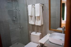 迪古拉Akiri Dhigurah的一间带卫生间、水槽和镜子的浴室