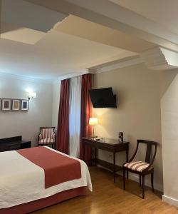卢塞纳卢塞纳圣多明各酒店的酒店客房,配有一张床、一张桌子和椅子