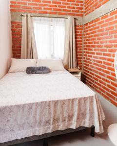 科马亚瓜Entre Pinos的一间卧室配有一张砖墙床