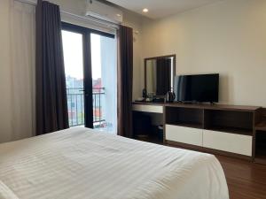 河内Paragon Noi bai Hotel & Pool的一间卧室设有一张床、一台电视和一个窗口。