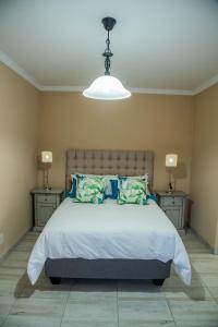 帕雷斯137 Vaal De Grace Golf Estate的一间卧室配有一张带2个床头柜的大床