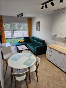 皮拉Apartament Konstancji的客厅配有绿色沙发和桌子