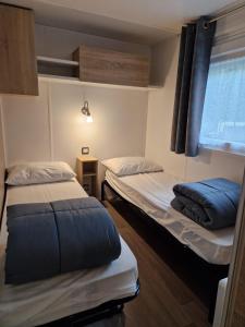 圣布里文莱丝皮恩Mobil home tout confort 3 chambres camping Les Pierres Couchées的小型客房 - 带2张床和窗户