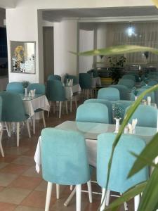 菲尼凯Deniz Hotel的一间配备有蓝色椅子和桌子的用餐室