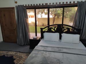 白沙瓦Askari Gold Crest的一间卧室设有一张床和一个大窗户