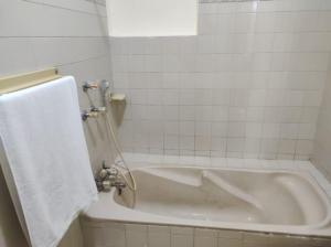 白沙瓦Askari Gold Crest的浴室设有白色浴缸,配有毛巾