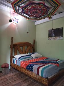 莫科阿POSADA KAUAI的一间卧室设有一张木床和色彩缤纷的天花板