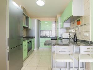 甘迪亚海滩Apartamento Balcon De Jandia的厨房配有绿色橱柜和冰箱。