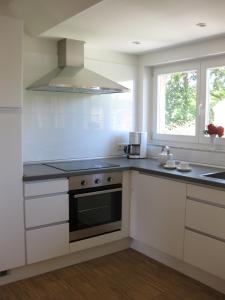 阿尔滕基兴Blue House Rügen的白色的厨房配有炉灶和窗户。