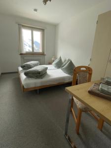 塞德龙Swiss Alpine Hideaway的一间卧室配有一张床、一张桌子和一个窗户。