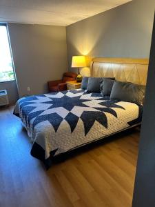 麦迪逊Madison Inn & Suites的一间卧室配有一张带蓝白色毯子的床