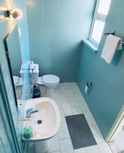 卡帕里卡海岸Central Atlantic Beach Guesthouse的蓝色的浴室设有水槽和卫生间