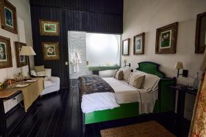 GarzónHotel Garzón的卧室配有绿色和白色的床和书桌。