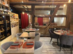 埃圭斯海姆Hotel Colmar Vignes Eguisheim的一间带木桌椅的餐厅和一间酒吧