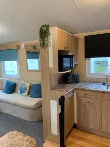 纽基Newquay Bay Porth Caravan - 8 Berth的一间大篷车内的小厨房,内配沙发