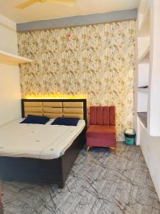 乌贾因Shivay homestay ujjain的一间卧室配有一张床和一把椅子