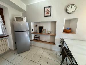 伦诺Appartamento Nido Del Lago的厨房配有冰箱和墙上的时钟