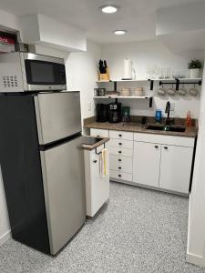夏延Basement Bliss: Cozy Getaway的厨房配有黑冰箱和白色橱柜。