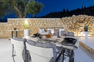 扎金索斯镇Dion Villa Zakynthos Greece的一个带石墙的庭院里的桌椅
