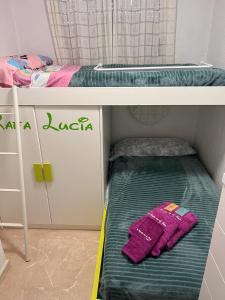 贝利雷瓜尔德Un Rincon en el Mar的双层床,上面有绿色和粉红色的毛巾