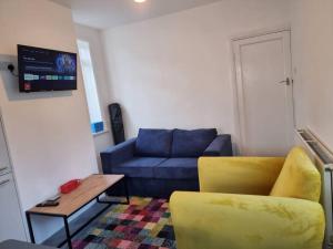 普里茅斯Radiant Accommodation Manor Lane的客厅配有蓝色的沙发和桌子