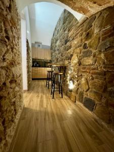 拉奎拉Maison Costa Masciarelli的厨房设有石墙和桌子
