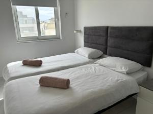 Is-SwieqiSpacious and Cozy Apartment near St Julians - Short Let Apartments Malta的带窗户的客房内设有两张单人床。