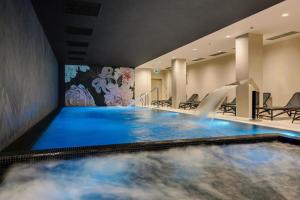 格但斯克GREAT Grano Residence的一座位于酒店客房的带瀑布的游泳池