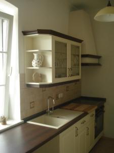 昂特保科洛佩因兰德佛尔克公寓的厨房配有白色橱柜、水槽和窗户。