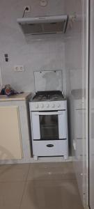 埃斯帕戈斯Apartamento T1 Mobilado Espargos/Sal的厨房配有白色炉灶和冰箱。