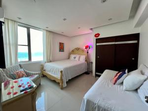圣胡安Condado Lux Oceanfront Tantra Ap的一间带两张床的卧室和一间客厅