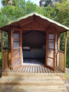 莫图伊卡Cozy Glamping Cabins的木制凉亭配有沙发