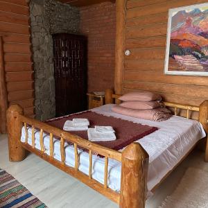 塞尼维斯卡波利亚纳Будинок Художника的一间卧室配有一张带毛巾的木床