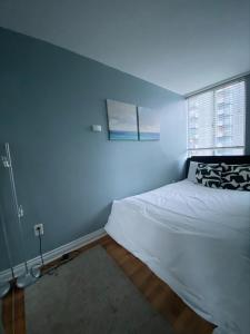 温哥华Condo in Downtown的卧室配有白色的床和窗户。