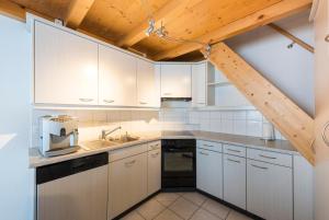 富如特奥贝莱夫鲁特九号公寓的厨房配有白色橱柜和木制天花板