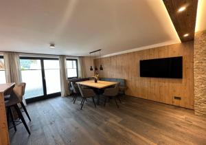 埃布斯Luxury Apartment, Kaisergebirge的一间设有桌子的用餐室和墙上的电视