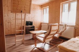 克维尔达Na Bučinské的一间设有两把椅子、一张桌子和一台电视的房间