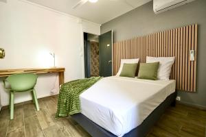 皮特尔角城La Suite Azur的一间卧室配有一张大床和一张绿色椅子